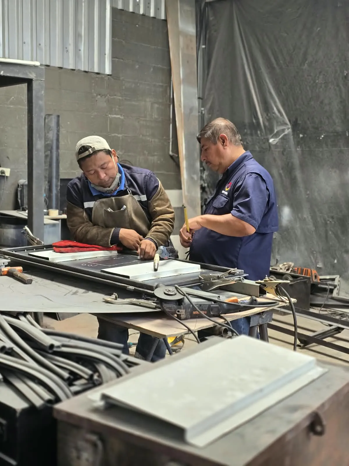 Dos técnicos armando una estructura en el taller